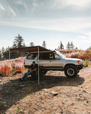 ROAM Adventure Co. Rooftop Awning provides shelter to someone enjoying the outdoors